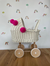 Load image into Gallery viewer, Wicker pram with bow, tall dolls pram, bow and bedding included. Cream/ off white pram with pink  pom-poms and bedding of your choice.
